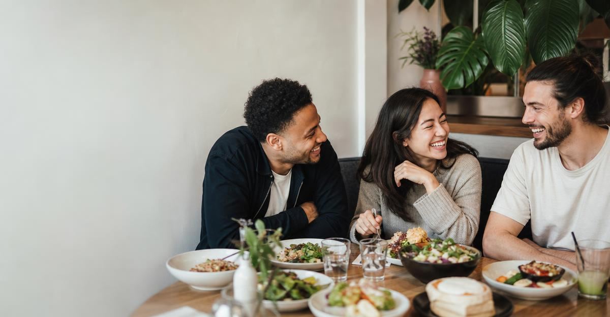 A group of friends laughing and enjoying a balanced meal together at a vibrant restaurant.